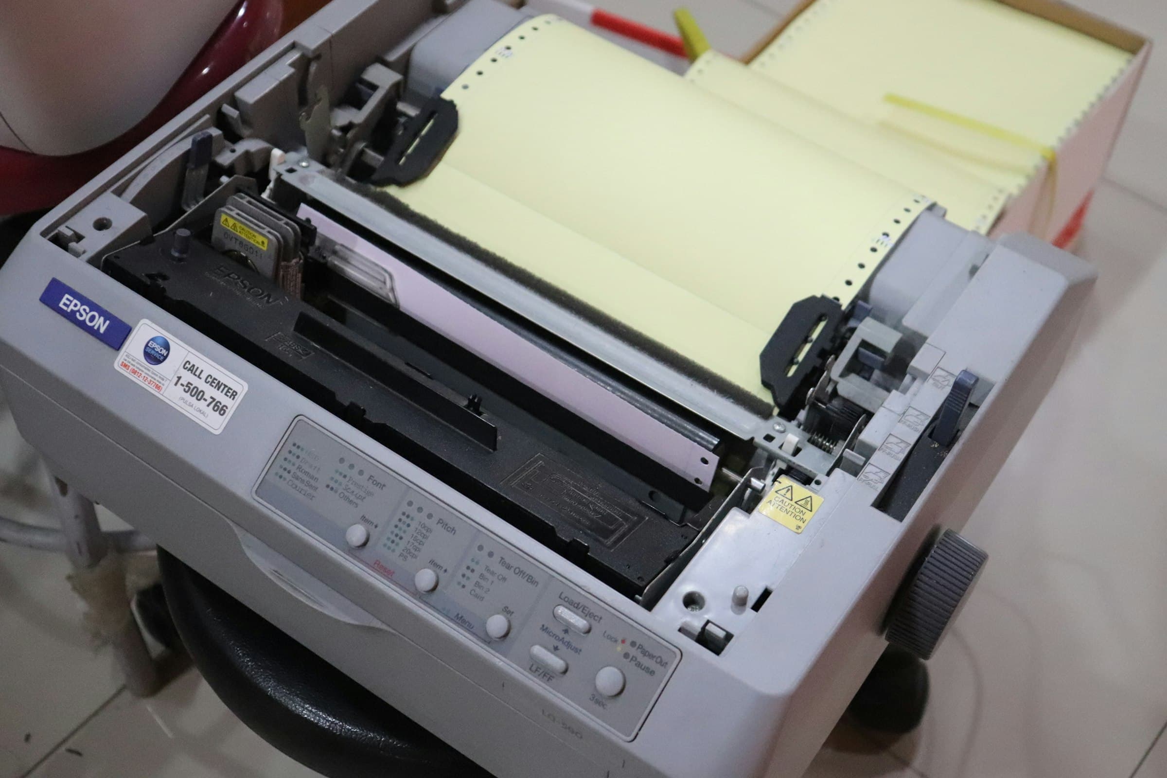 An office printer and fax machine, paper loaded.
