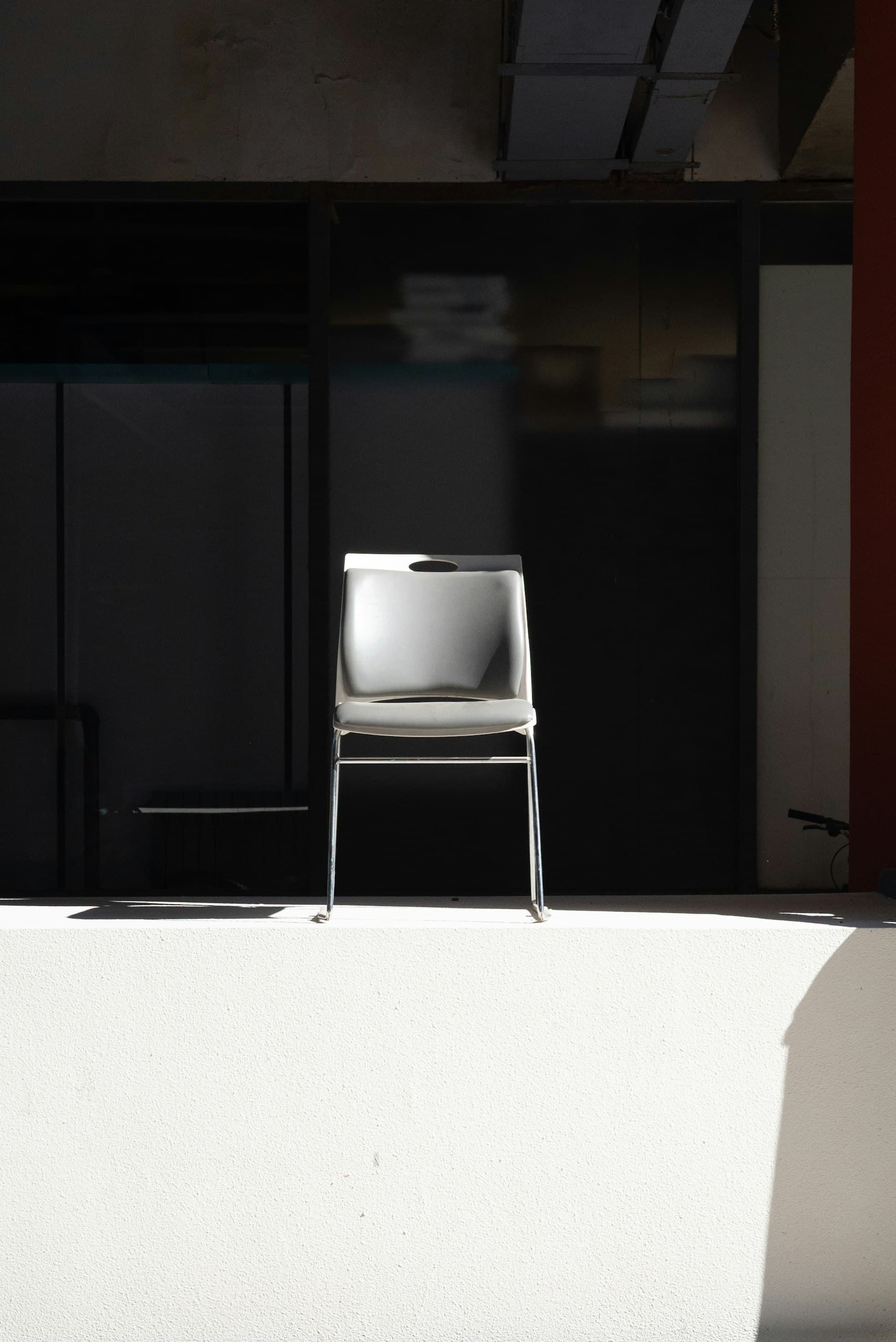A single empty chair in a bright, bare room.